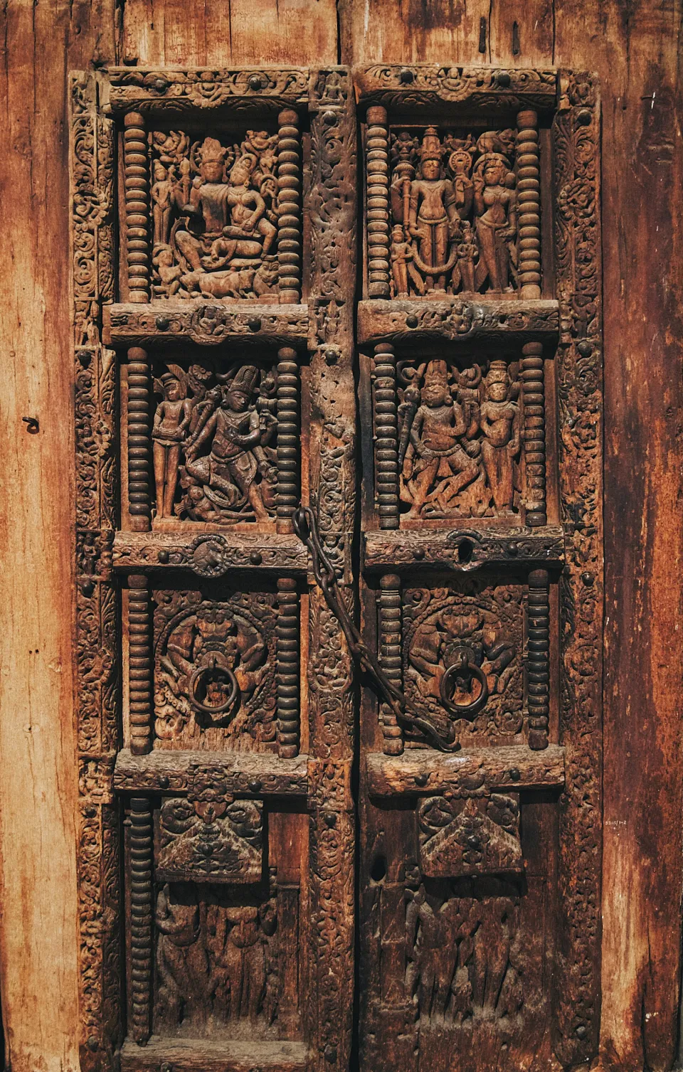 Old wooden door with deeply carved figure panels