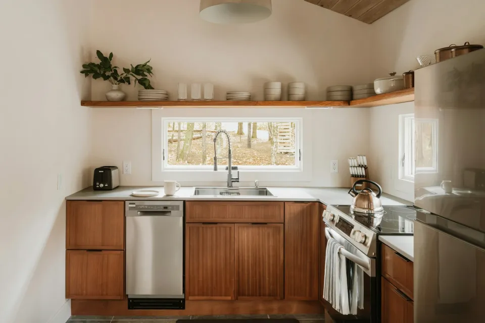 Kitchen with wooden lower cabinets, open shelf and a window